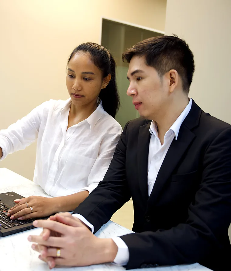 สมาชิกทีม YPN Accounting สองคนพิจารณาความต้องการลูกค้าที่แล็ปท็อป