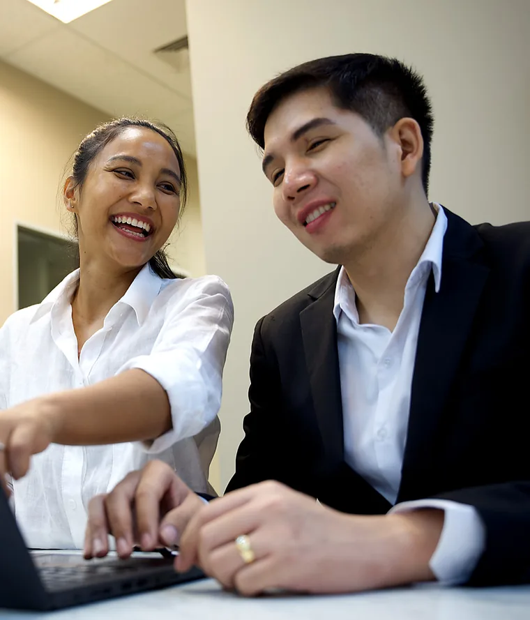 Yupin Numyen หัวเราะกับเพื่อนร่วมงานขณะทำงานที่แล็ปท็อป